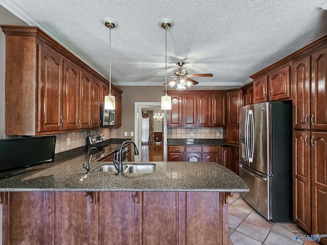 kitchen featuring ceiling fan with notable chandelier, kitchen peninsula, hanging light fixtures, backsplash, and appliances with stainless steel finishes