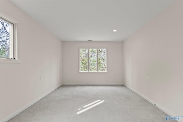 empty room with a healthy amount of sunlight and light carpet