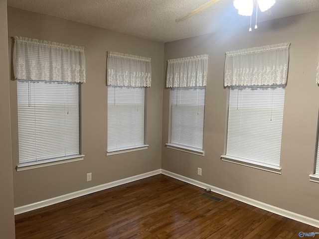 unfurnished room featuring a textured ceiling, dark hardwood / wood-style floors, and ceiling fan