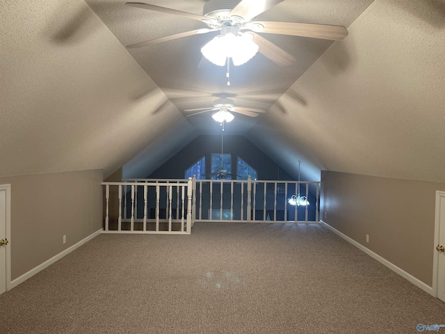 additional living space featuring ceiling fan, a textured ceiling, vaulted ceiling, and carpet