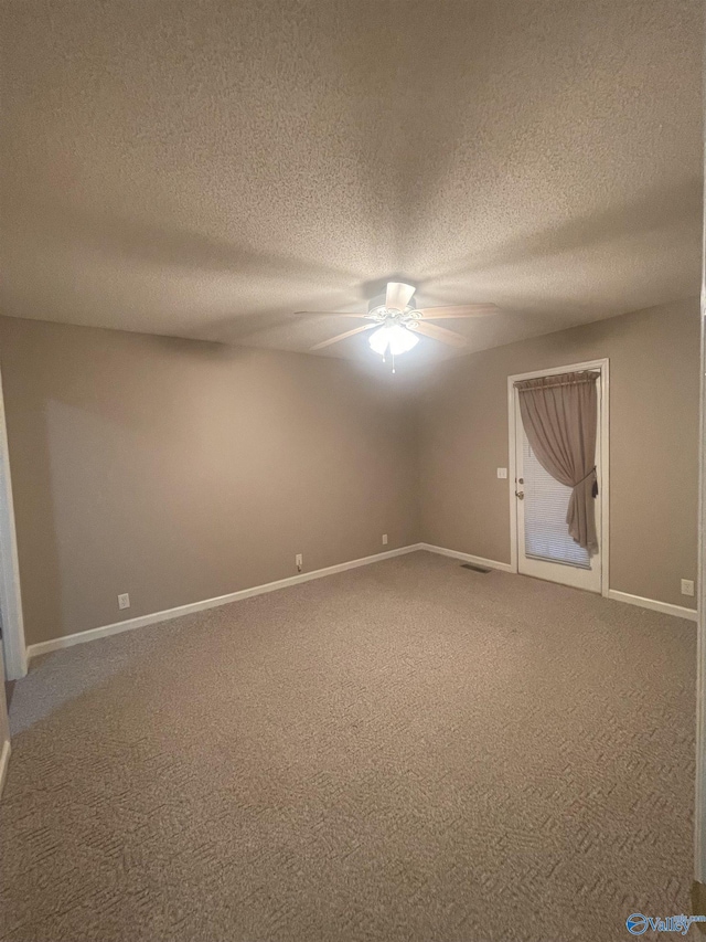 carpeted spare room with a textured ceiling and ceiling fan