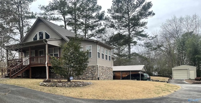 view of front of property with a garage, covered porch, an outdoor structure, and a carport