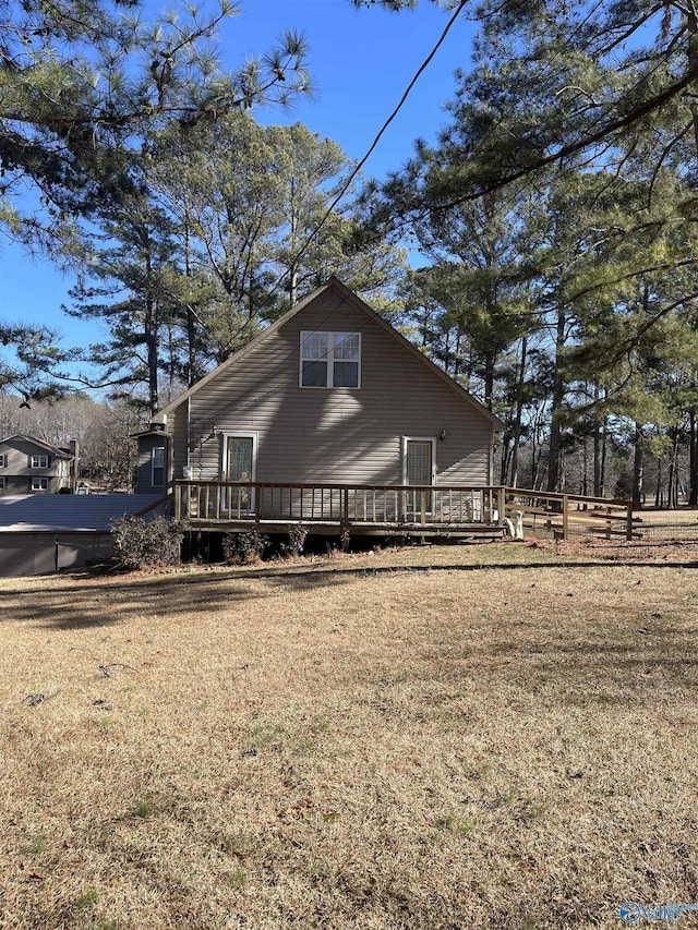 view of side of property featuring a wooden deck and a lawn