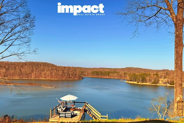 view of dock with a water view and a forest view