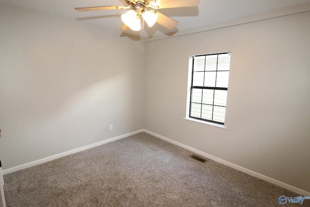 carpeted spare room featuring baseboards, a ceiling fan, and visible vents