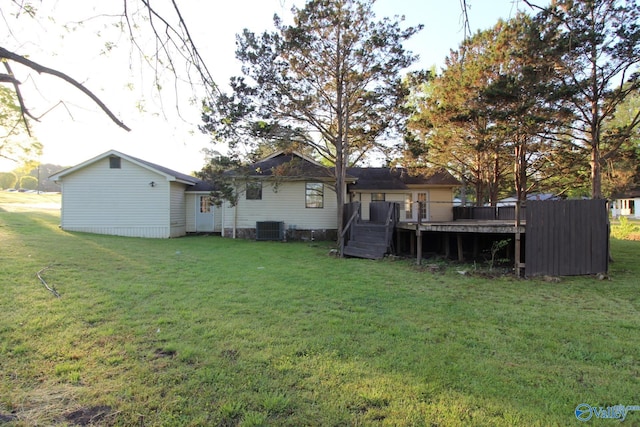 rear view of house with a yard, a deck, and cooling unit