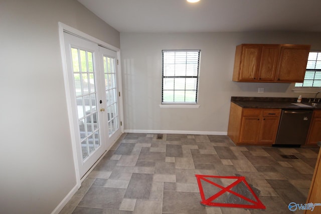 kitchen featuring dark countertops, baseboards, french doors, a sink, and dishwasher
