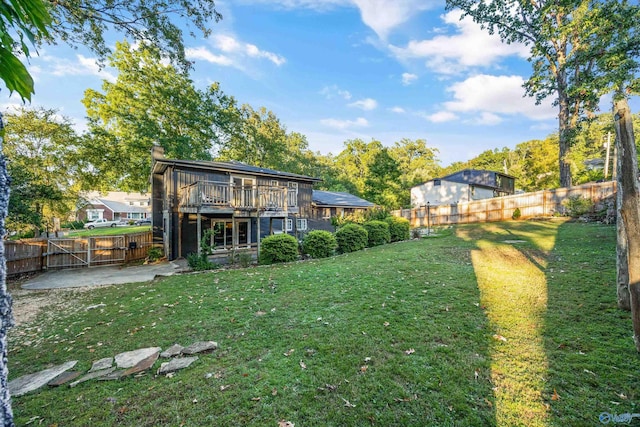 back of house featuring a deck, a lawn, and a patio