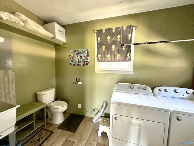 interior space with light wood-type flooring, laundry area, baseboards, and washer and clothes dryer