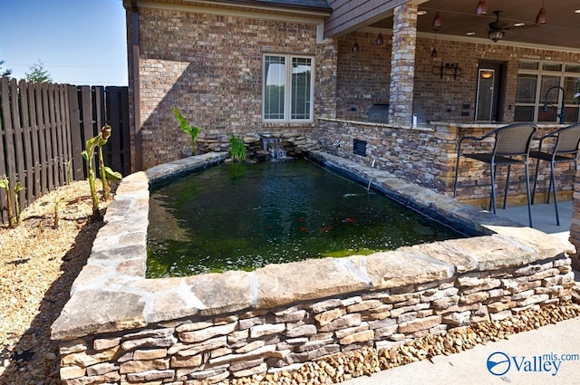 24188 Newby Rd, Madison, AL 35756 - exterior space featuring a pool, outdoor dry bar, a fenced backyard, ceiling fan, and a small pond