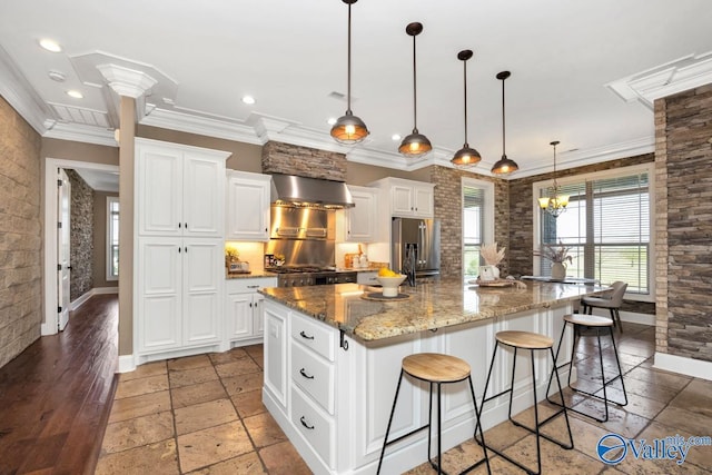24188 Newby Rd, Madison, AL 35756 - kitchen with stainless steel fridge, a spacious island, white cabinetry, wall chimney range hood, and ornamental molding