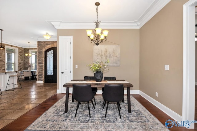 24188 Newby Rd, Madison, AL 35756 - dining area featuring dark wood finished floors, an inviting chandelier, crown molding, and baseboards