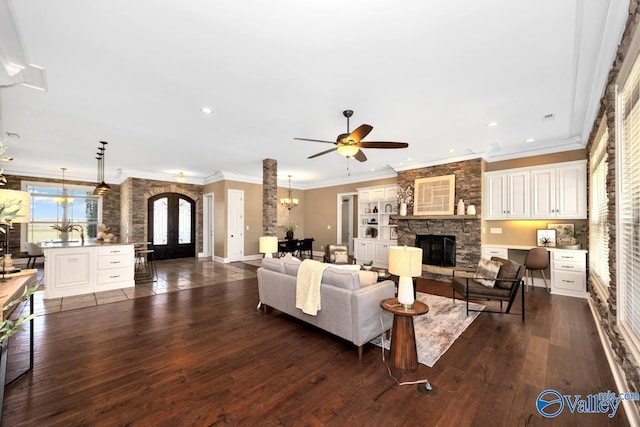 24188 Newby Rd, Madison, AL 35756 - living area with recessed lighting, a stone fireplace, crown molding, dark wood-style flooring, and ceiling fan with notable chandelier