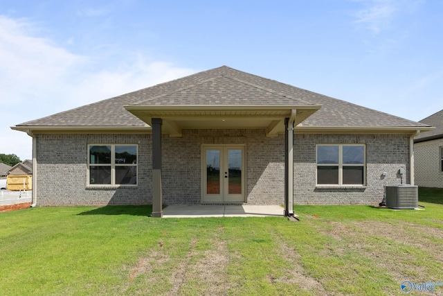 rear view of house featuring french doors, a patio, cooling unit, and a lawn