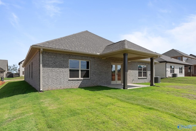 rear view of house with a yard, central AC, and a patio area