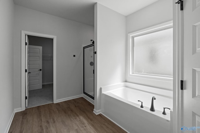 bathroom with hardwood / wood-style flooring and shower with separate bathtub