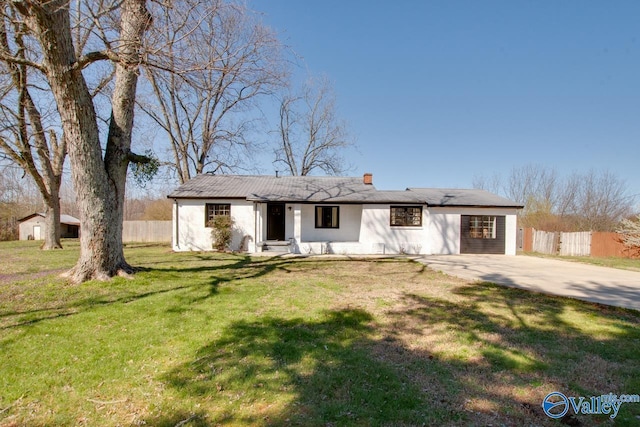 ranch-style house featuring a chimney, a front yard, and fence