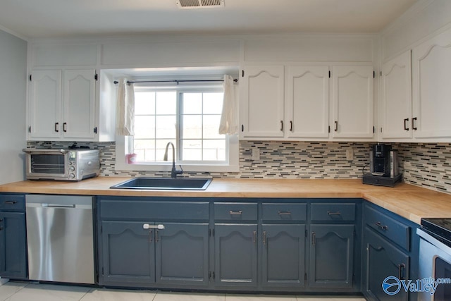 kitchen featuring a sink, stainless steel appliances, and wood counters