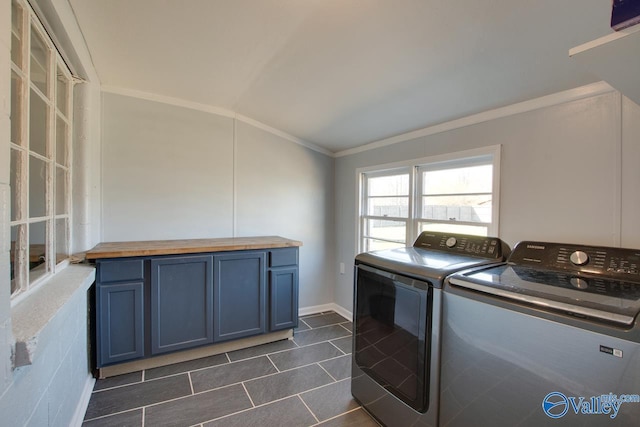 laundry room with cabinet space, separate washer and dryer, dark tile patterned floors, and crown molding