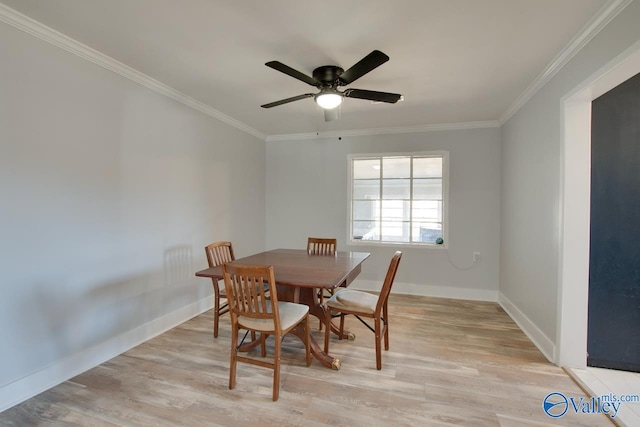 dining area with light wood-type flooring, baseboards, and crown molding