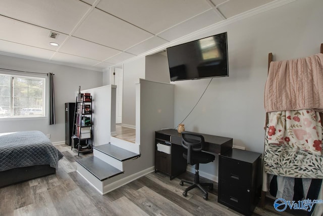 bedroom featuring visible vents, ornamental molding, a drop ceiling, wood finished floors, and baseboards