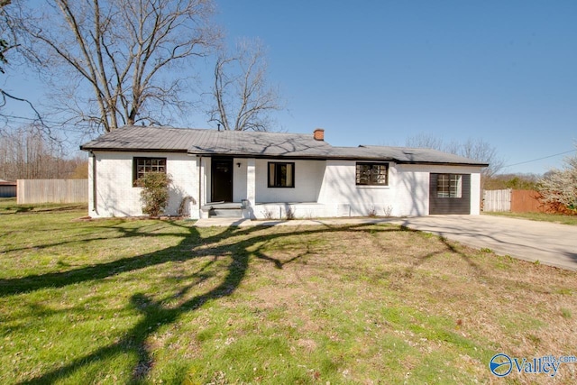 ranch-style house with a front yard, fence, driveway, a chimney, and brick siding