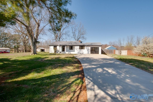 view of front of house featuring driveway, a front yard, and fence