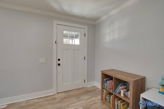 foyer entrance featuring baseboards, crown molding, and light wood finished floors