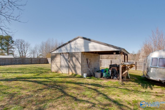 exterior space with an outdoor structure, a lawn, and fence