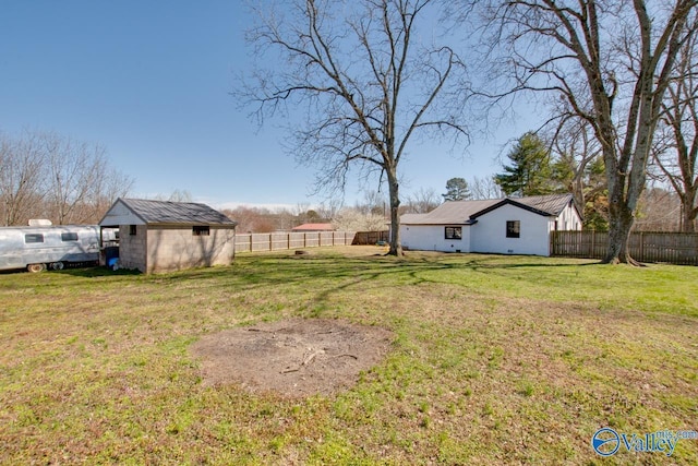 view of yard featuring an outbuilding, a storage shed, and a fenced backyard