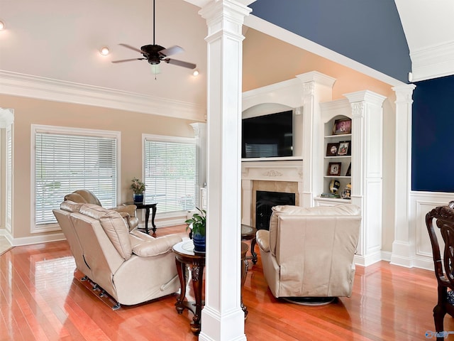 1103 Blackbriar Cir, Hartselle, AL 35640 - living area featuring a ceiling fan, light wood finished floors, a fireplace, vaulted ceiling, and decorative columns