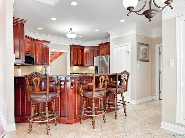 1103 Blackbriar Cir, Hartselle, AL 35640 - kitchen with stainless steel appliances, reddish brown cabinets, backsplash, baseboards, and recessed lighting