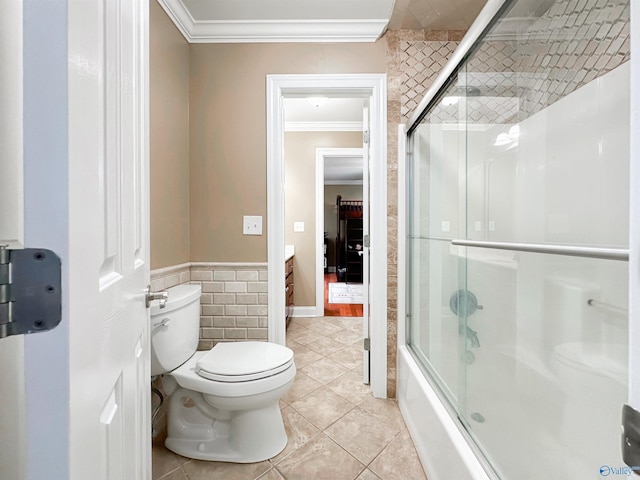 1103 Blackbriar Cir, Hartselle, AL 35640 - bathroom featuring tile walls, crown molding, tile patterned floors, toilet, and bath / shower combo with glass door
