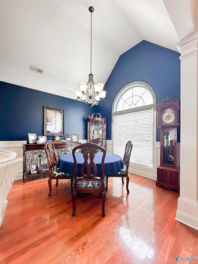 1103 Blackbriar Cir, Hartselle, AL 35640 - dining space featuring a chandelier, wainscoting, vaulted ceiling, wood finished floors, and a decorative wall
