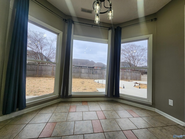 unfurnished dining area with tile patterned floors, baseboards, and visible vents