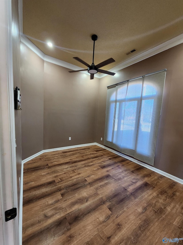 spare room featuring baseboards, a ceiling fan, wood finished floors, and ornamental molding