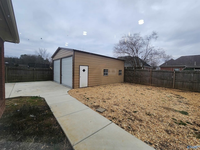 view of yard featuring an outdoor structure, fence, and a detached garage