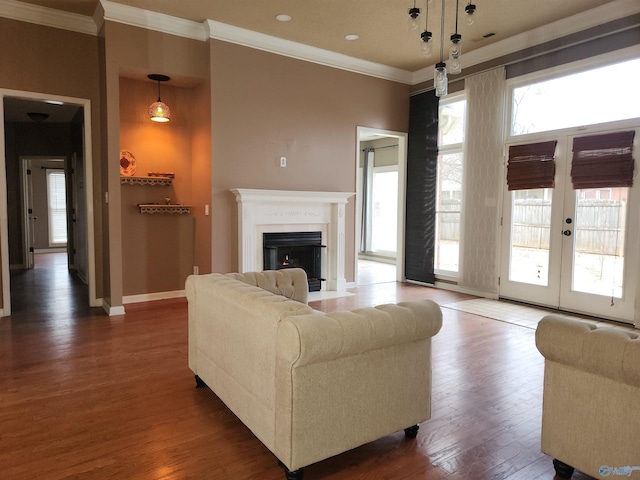 living room featuring wood finished floors, a fireplace with flush hearth, french doors, baseboards, and ornamental molding
