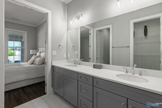 bathroom with wood-type flooring, vanity, and ornamental molding