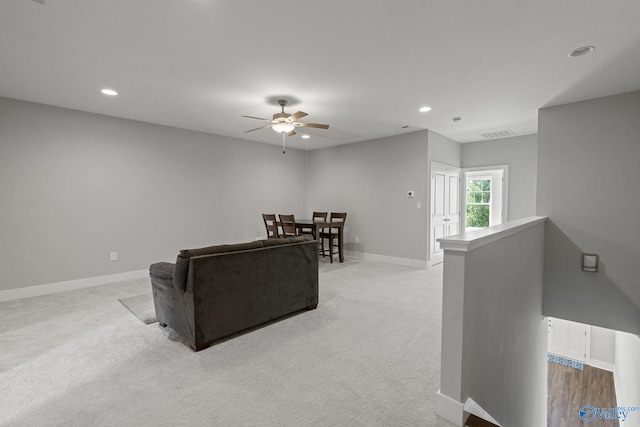 carpeted living room with ceiling fan