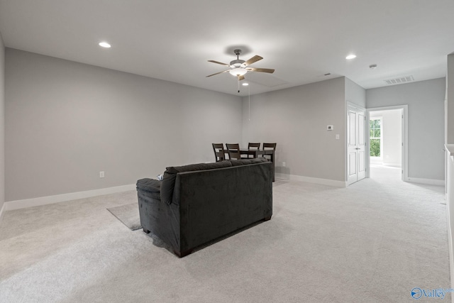 living room with ceiling fan and light colored carpet