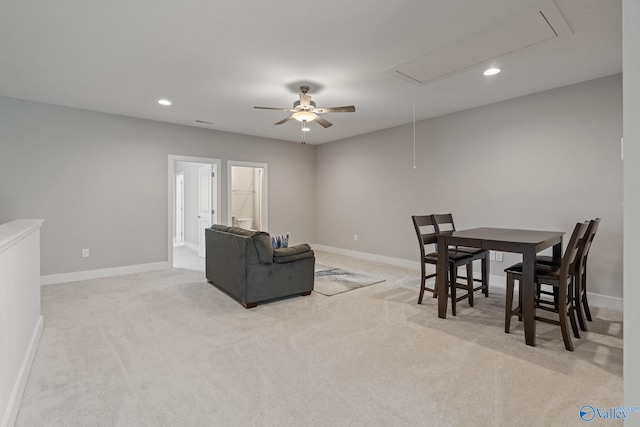 dining space featuring ceiling fan and light colored carpet