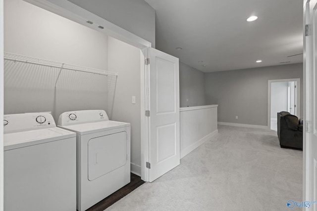 laundry room with light colored carpet and washer and dryer