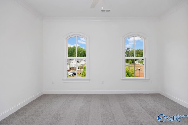 spare room with crown molding, light colored carpet, and ceiling fan