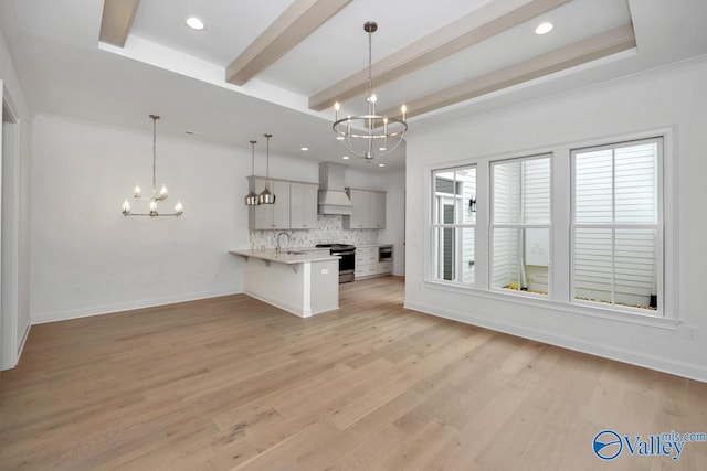 kitchen featuring a breakfast bar, pendant lighting, a chandelier, and kitchen peninsula