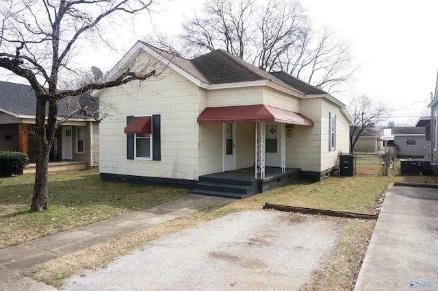 bungalow-style house featuring a shingled roof, a front yard, and a gate