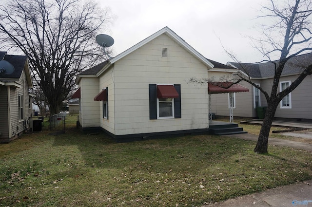 view of side of home featuring central AC unit and a lawn