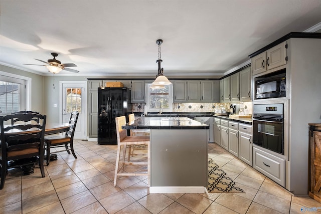 kitchen with gray cabinets, a center island, black appliances, decorative backsplash, and ornamental molding