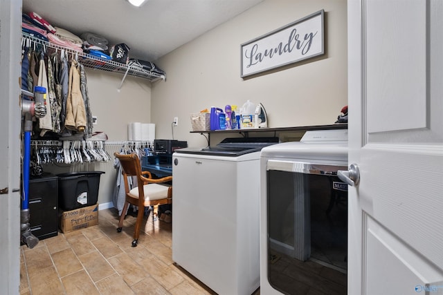 clothes washing area with washing machine and dryer and light hardwood / wood-style floors