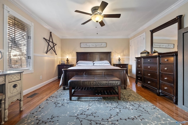 bedroom with ceiling fan, crown molding, multiple windows, and hardwood / wood-style floors